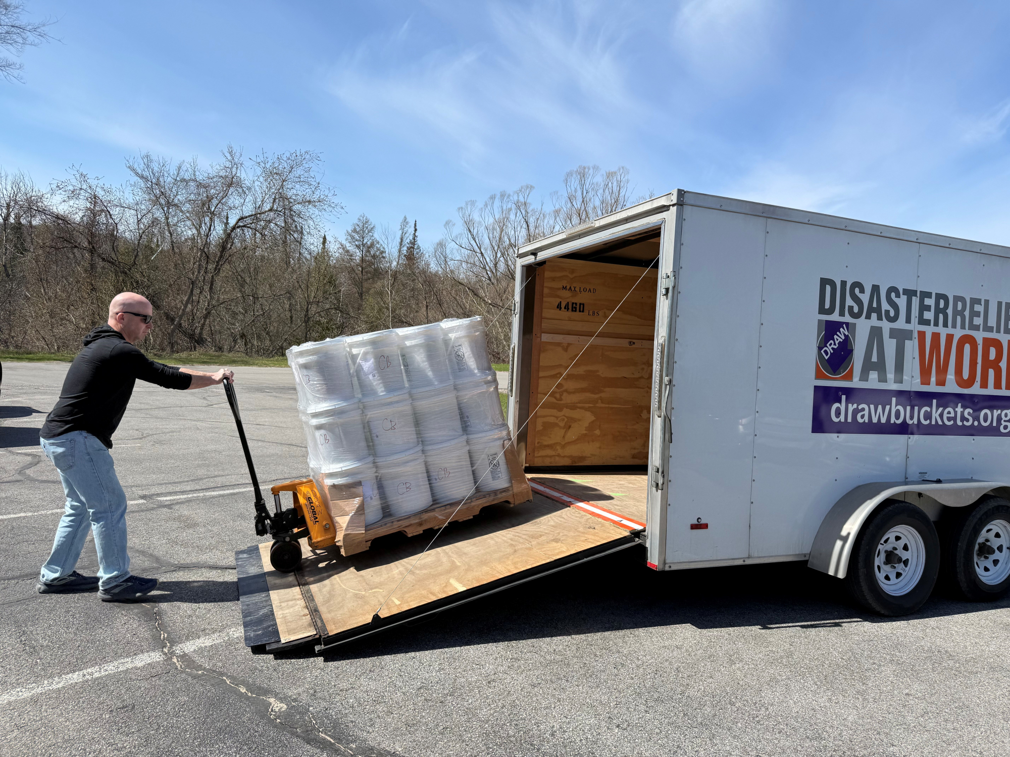 Volunteers with Disaster Relief at Work unload a pallet of disaster relief clean up supplies for Cheboygan County residents impacted by flooding.