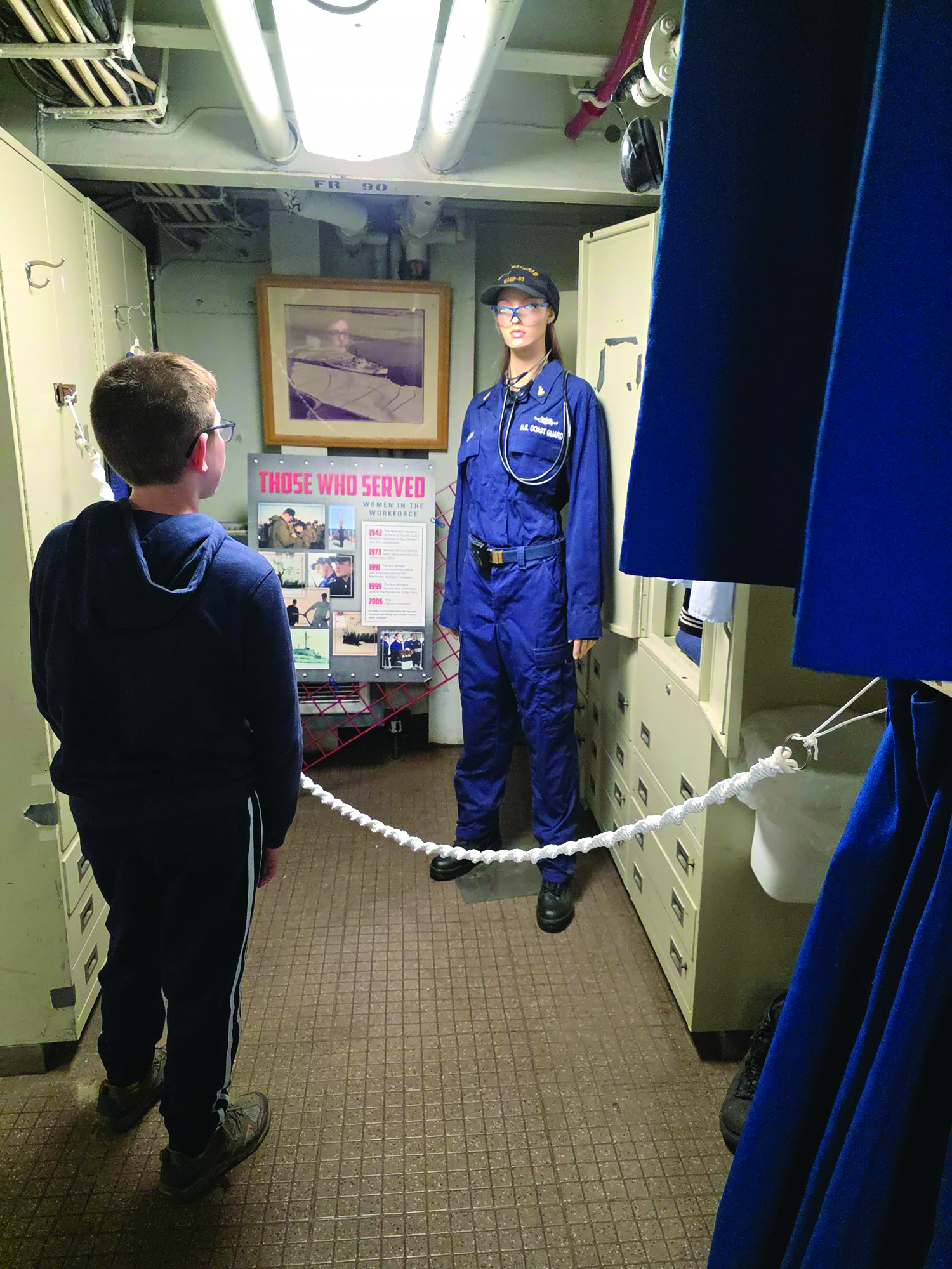 A young boy looks at the women's display at the Icebreaker Mackinaw Maritime Museum.