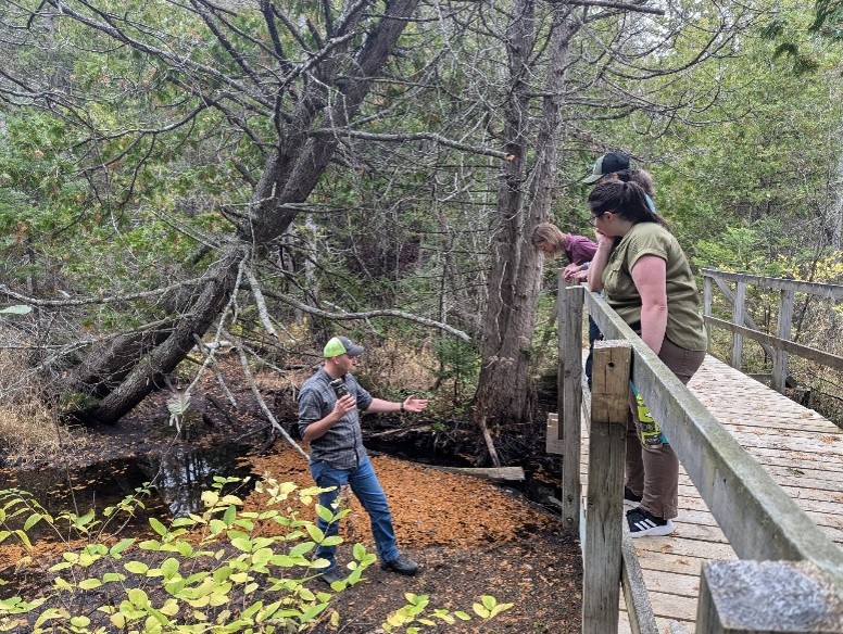 Presque Isle Conservation District Forester Jacob Grochowski shares details with CFNEM representatives on bridge updates at the Herman Vogler Preserve in 2024, before ice and flood damage.