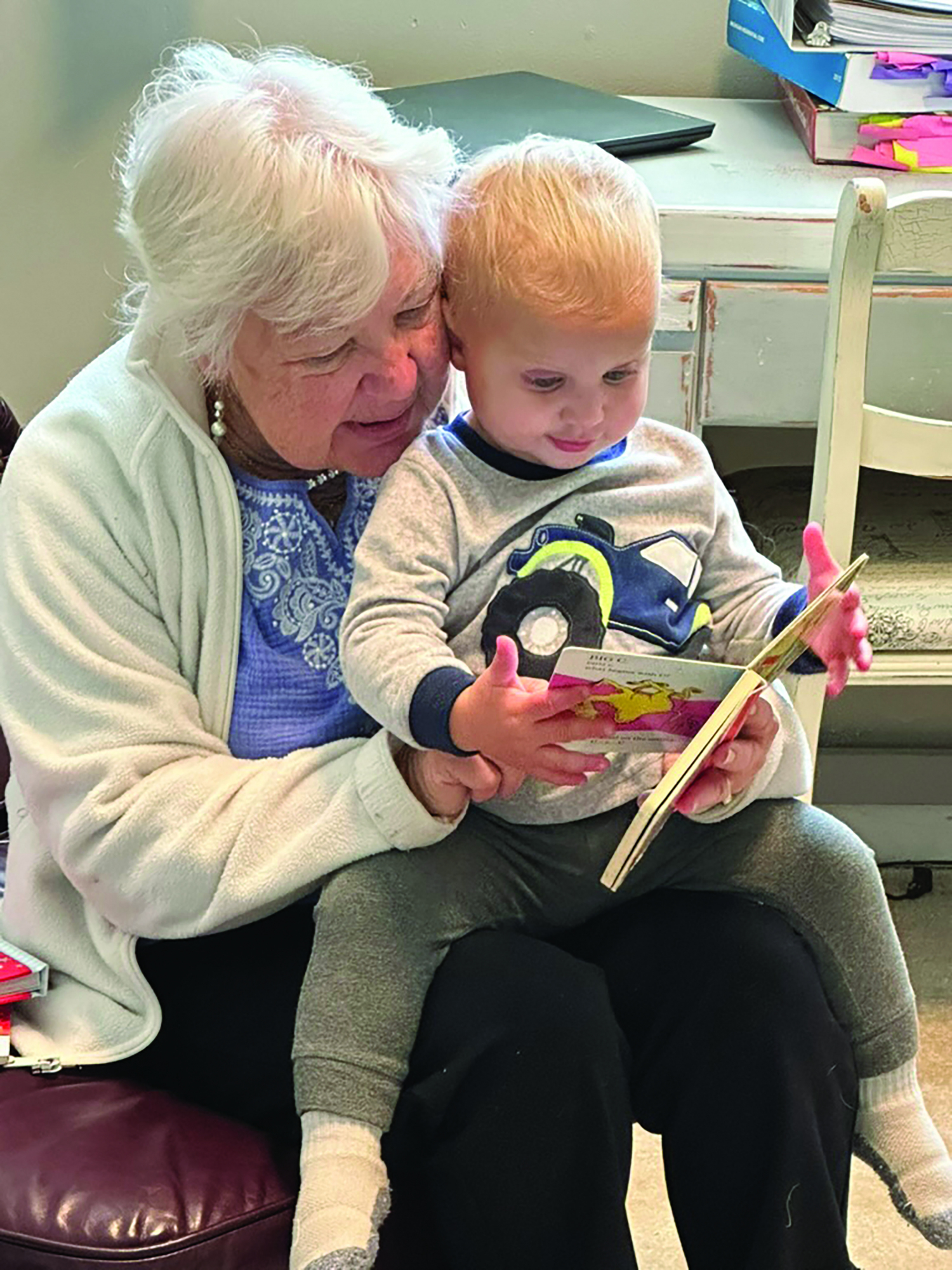 A woman reads to a toddler. : PoWeR! Book Bags’ Little Learners program focuses on early childhood literacy. Photo courtesy of PoWeR! Book Bags.